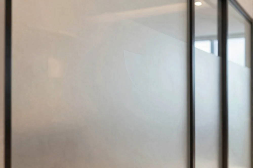 Window Graphics Dubai: Transform Your Retail Space 2 Elegant frosted window film with a geometric pattern providing privacy and a professional look.