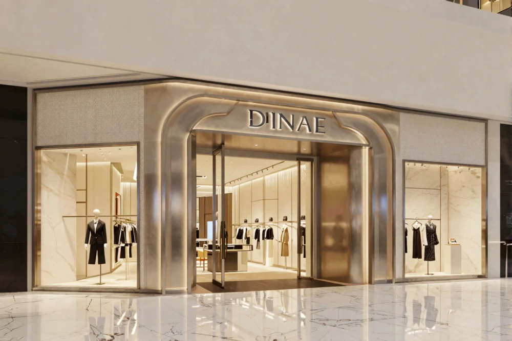 A high-end retail storefront in a Dubai mall with elegant 3D signage and marble floors.